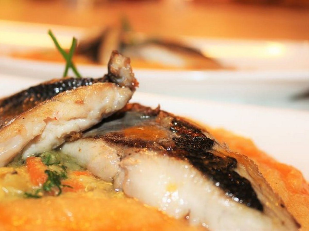 A mouthwatering plate of fish with a side of pureed potatoes smothered in flavorful gravy, inviting and satisfying.