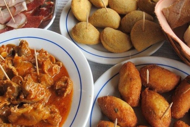 Braga Food Tour: sampling gizzards, codfish cakes, bread, and other local specialties at a vibrant street market in Braga.