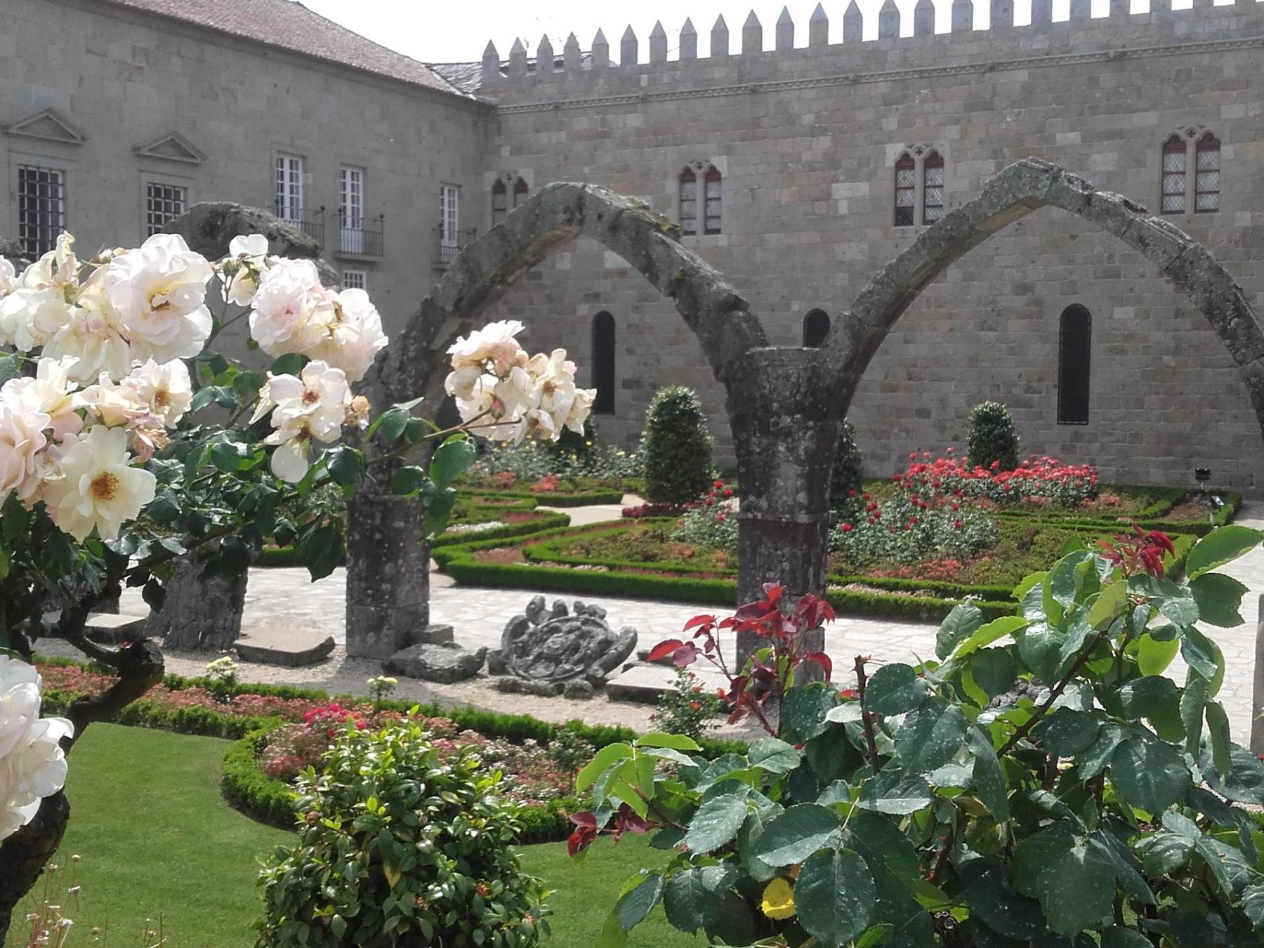 Colorful flowers and elegant arches create a charming courtyard scene at Saint Barbara Garden in Braga.