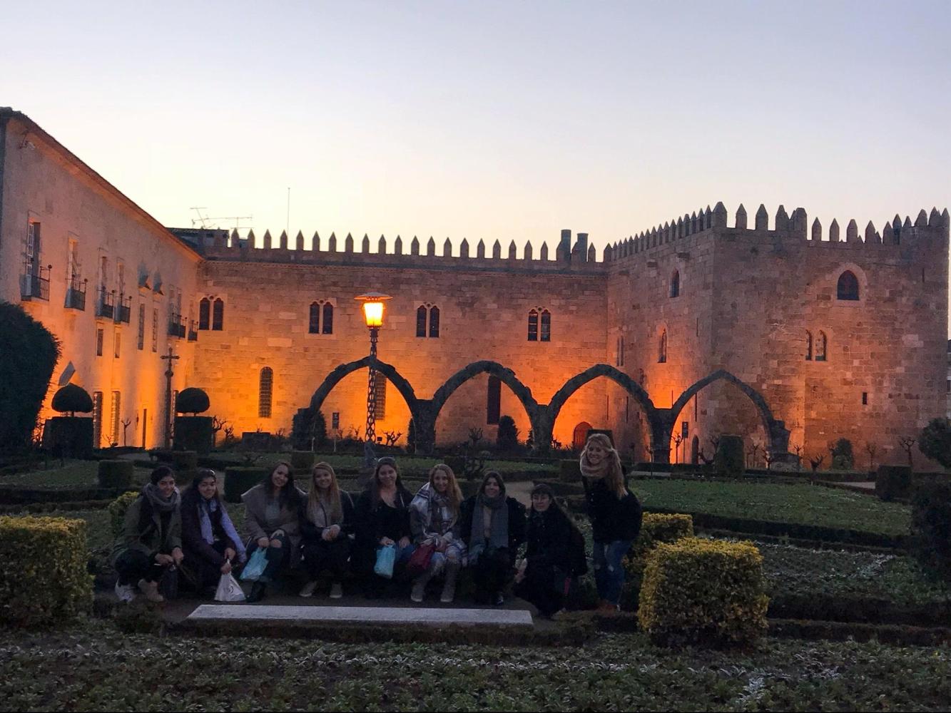 A small group of tourists smiles for a photo in the garden during their Braga tour.
