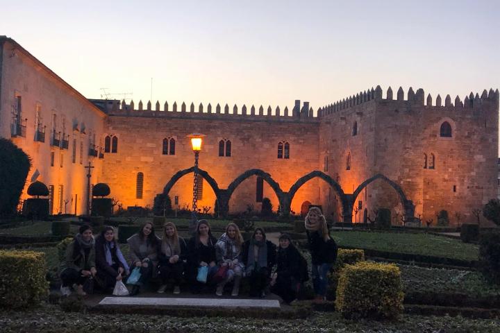 A small group of tourists smiles for a photo in the garden during their Braga tour.
