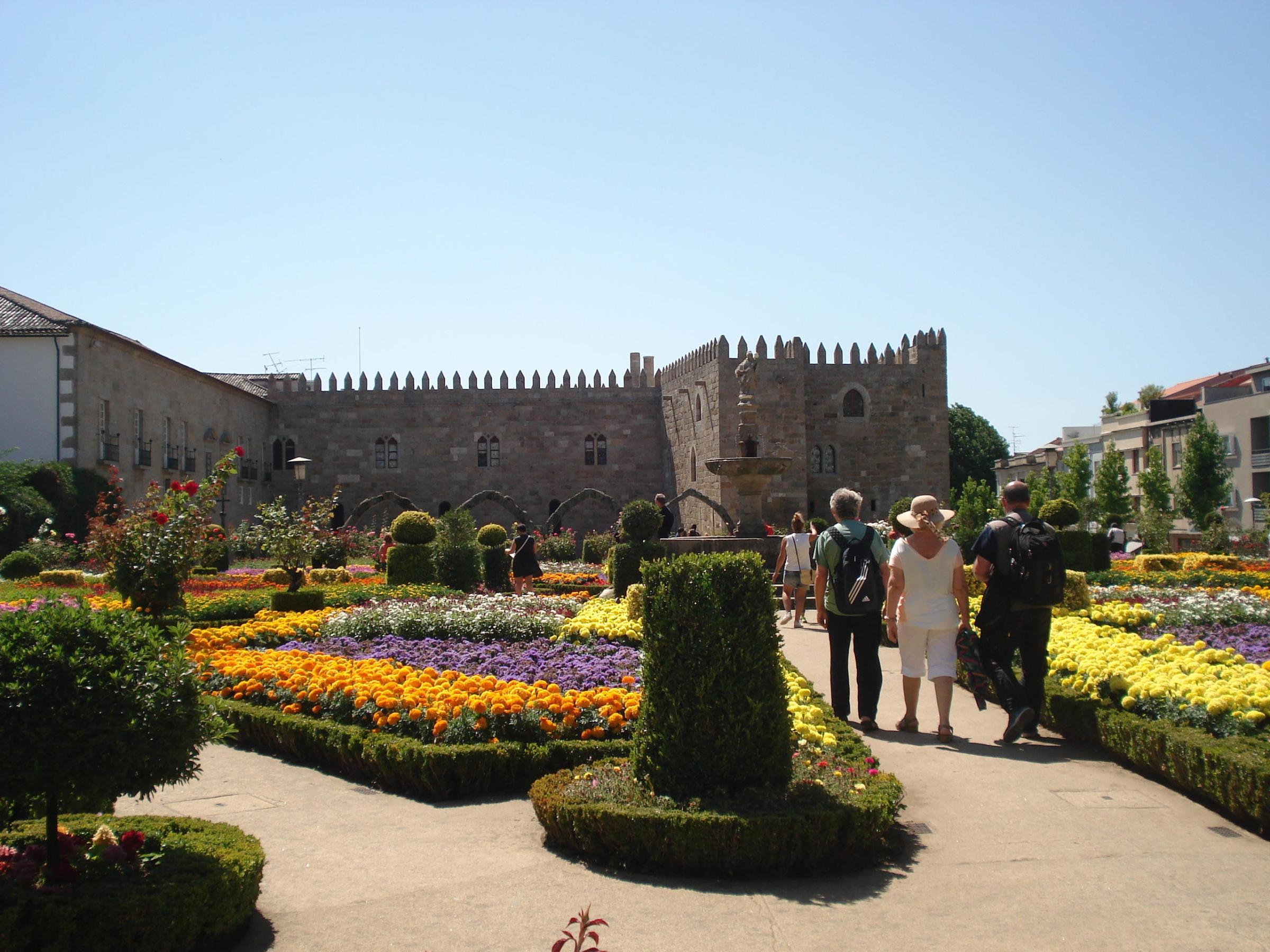 A small group of tourists exploring the lush greenery and historical features of Santa Barbara Garden in Braga.