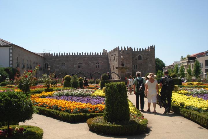 A small group of tourists exploring the lush greenery and historical features of Santa Barbara Garden in Braga.