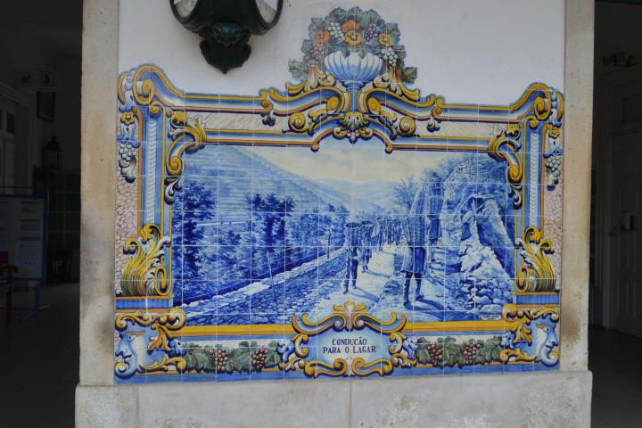 A decorative blue and white tile from the Pinhão train station, featuring beautiful designs that reflect local artistry.