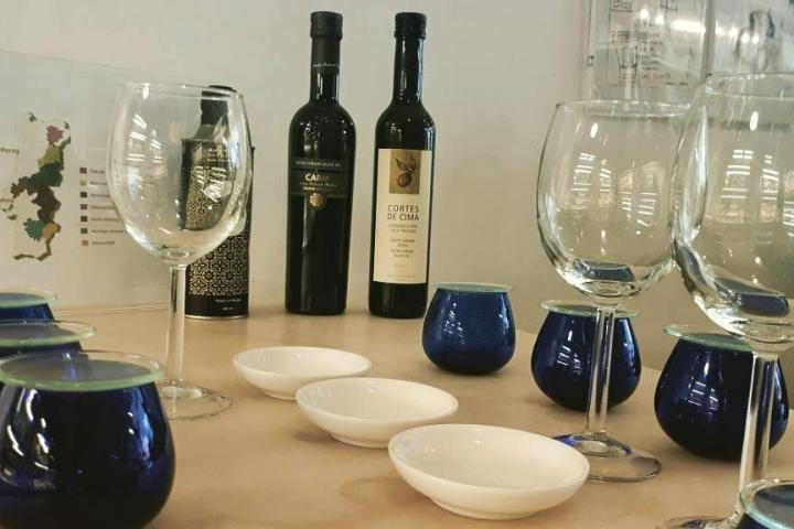Setting the table for an olive oil tasting with wine and bread in Porto, featuring a rustic tablecloth and elegant glassware.