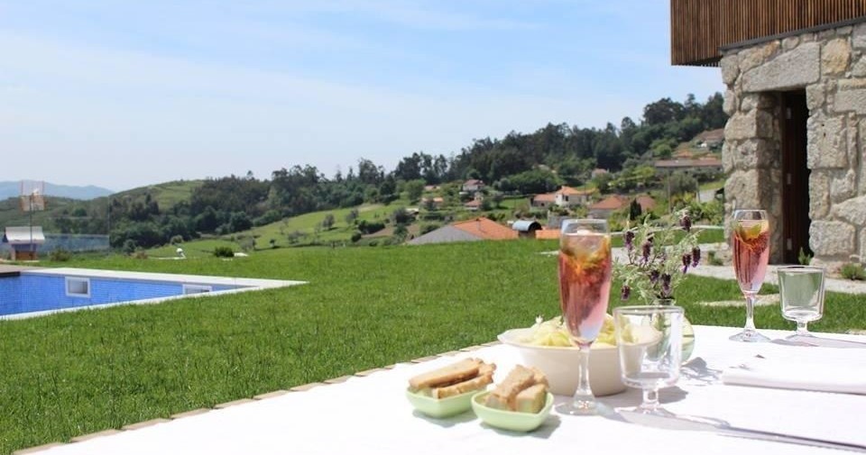 A beautifully set table with sangria and delicious food, overlooking a serene hotel pool, perfect for culinary vacations.