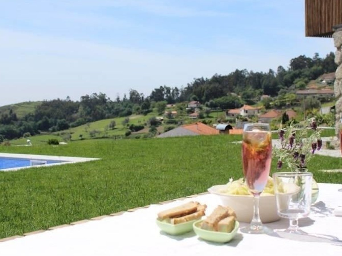 A beautifully set table with sangria and delicious food, overlooking a serene hotel pool, perfect for culinary vacations.