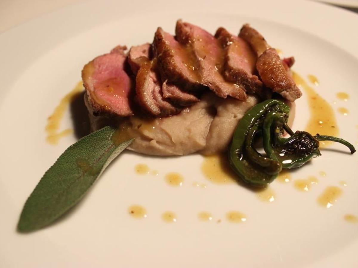 A tender piece of beef on a plate, beautifully garnished with sauce, representing the essence of Portuguese cuisine.