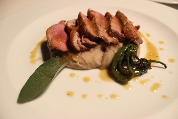 A tender piece of beef on a plate, beautifully garnished with sauce, representing the essence of Portuguese cuisine.