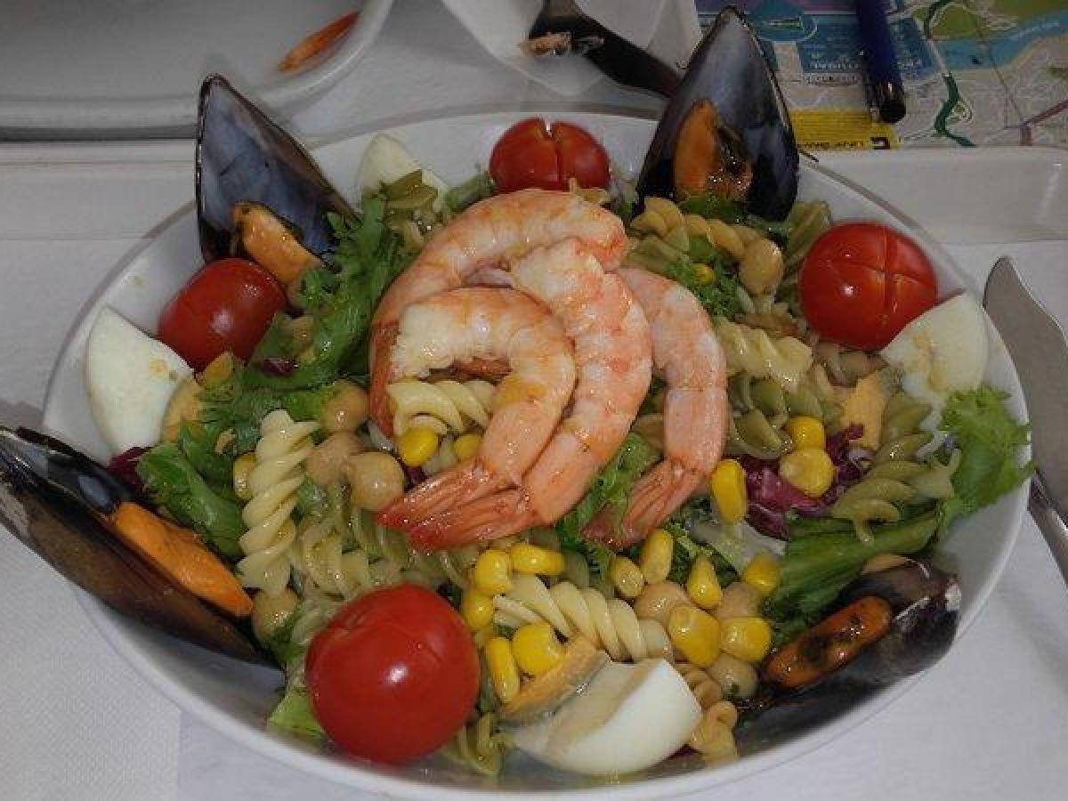 A vibrant plate featuring succulent shrimp salad, and fresh vegetables, perfect for a Portuguese food tour experience.