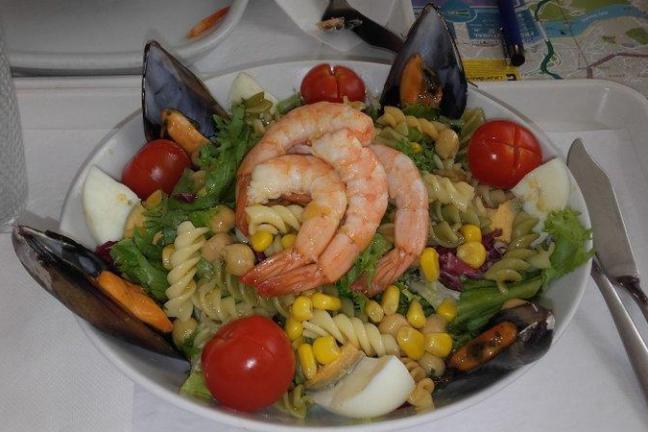 A vibrant plate featuring succulent shrimp salad, and fresh vegetables, perfect for a Portuguese food tour experience.