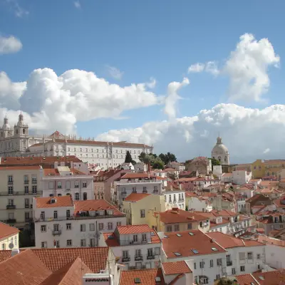 Bird's-eye view of Lisbon, featuring iconic rooftops and picturesque streets in warm sunlight.