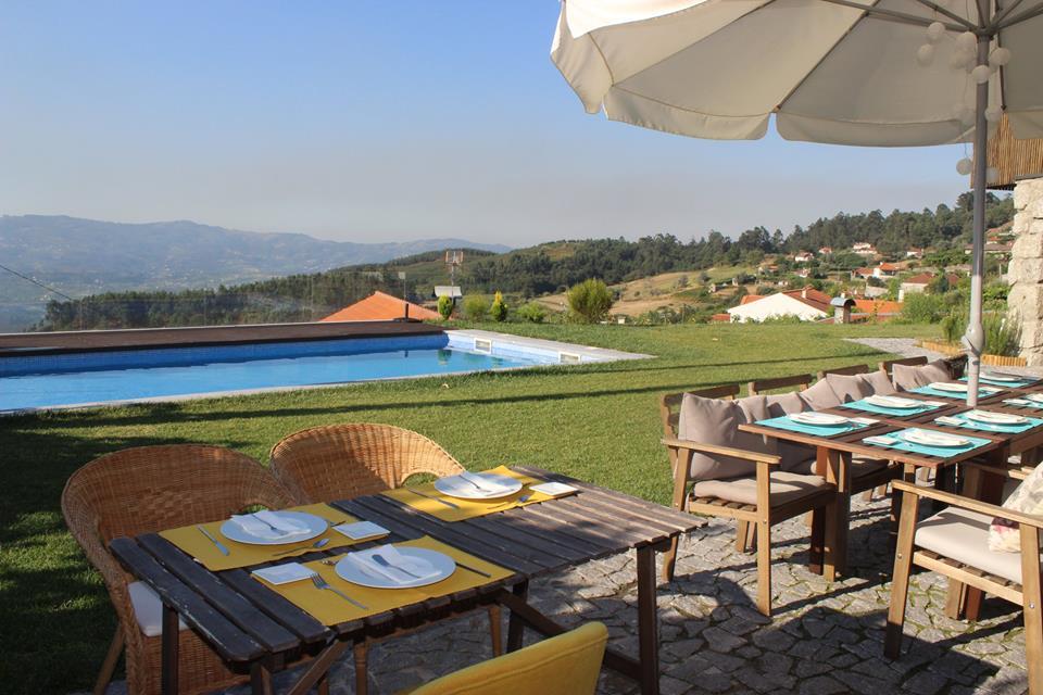 A serene hotel poolside scene featuring an umbrella and chairs on lush grass, perfect for culinary vacation relaxation.