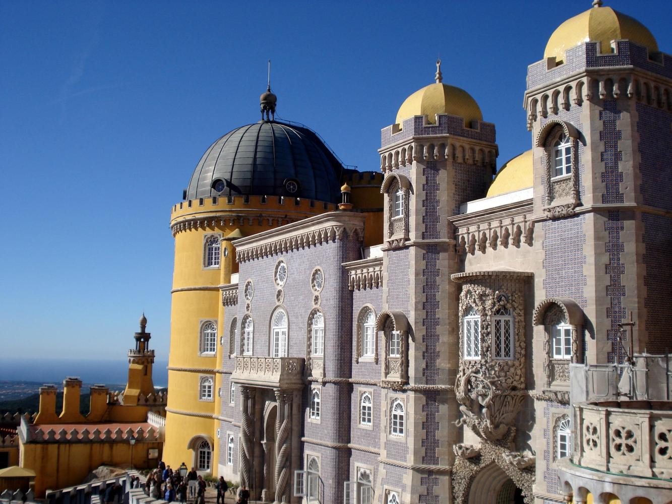 A stunning view of Pena Palace, with its large structure and numerous windows against a clear sky.