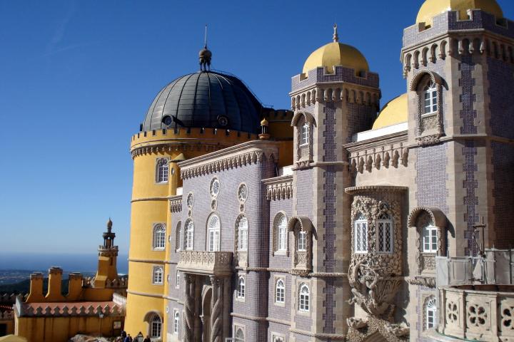 A stunning view of Pena Palace, with its large structure and numerous windows against a clear sky.