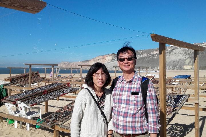 A man and woman enjoy a scenic moment together on Nazare beach during a small-group sightseeing tour.