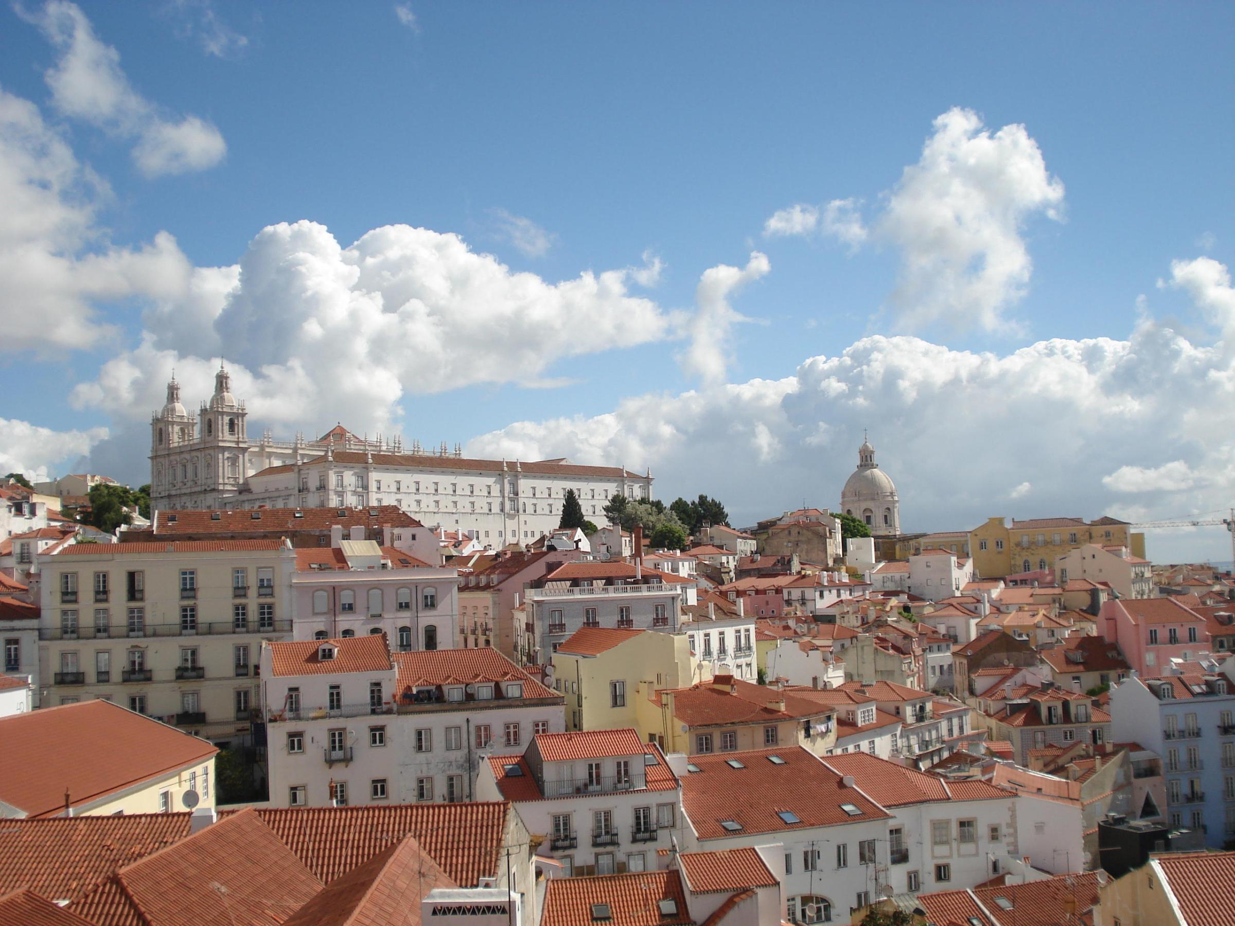 view of Lisbon, showcasing colorful buildings and a bright blue sky.