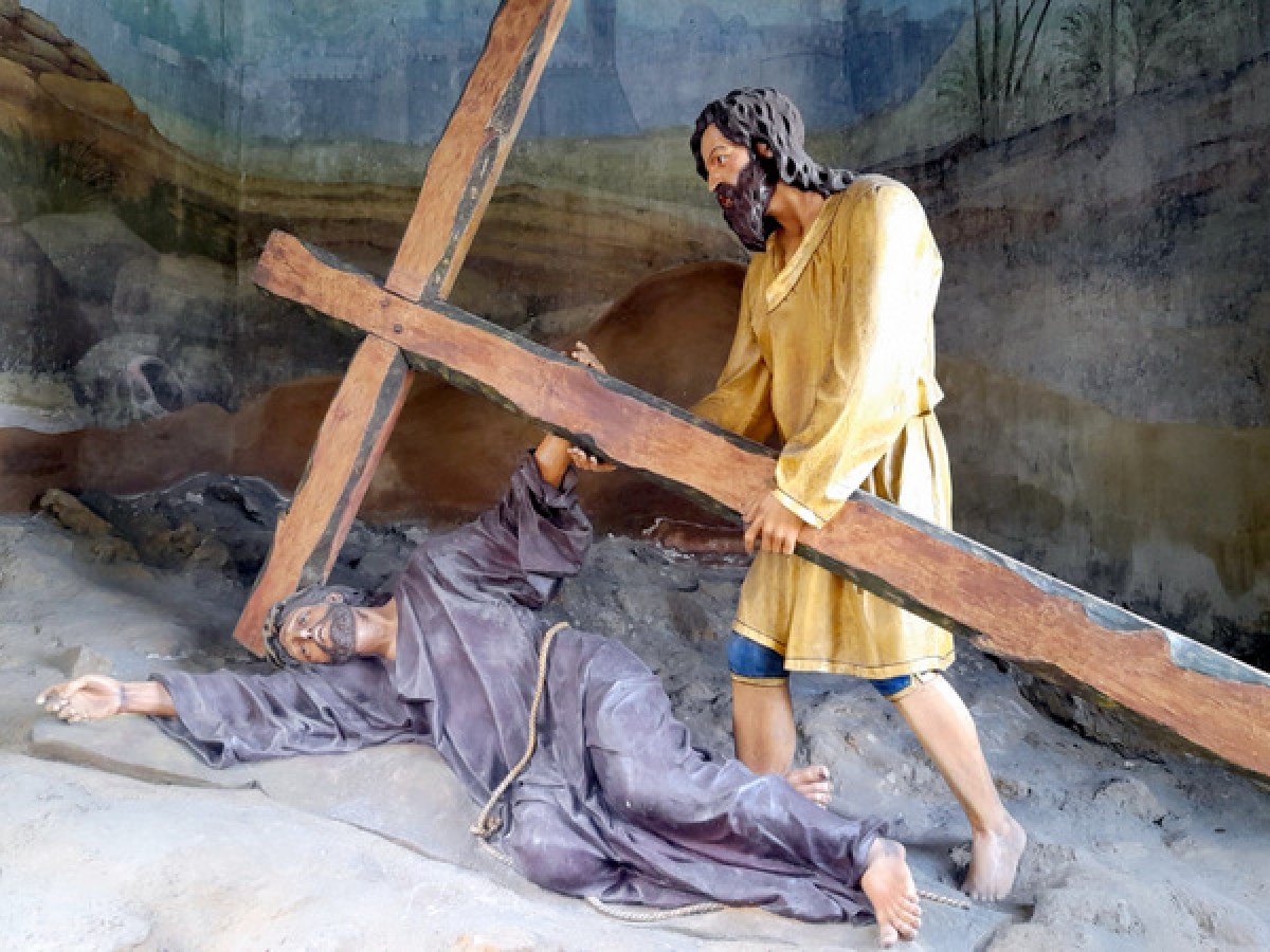 A statue of Jesus on the cross, symbolizing sacrifice, with a backdrop of the Braga tour highlighting Simon's support.