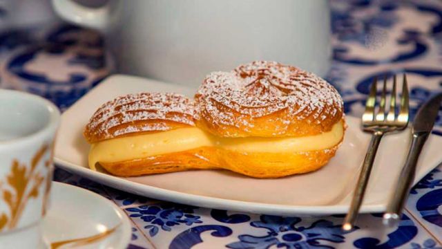 A white plate holds a tibia cake, showcasing delicious pastries from the Braga food tour experience.