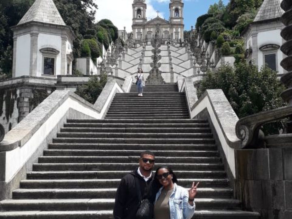 A couple stands together in front of the stunning Bom Jesus Church during their Braga sightseeing tour.