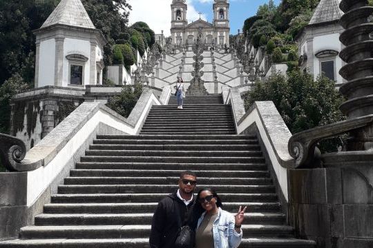 A couple stands together in front of the stunning Bom Jesus Church during their Braga sightseeing tour.