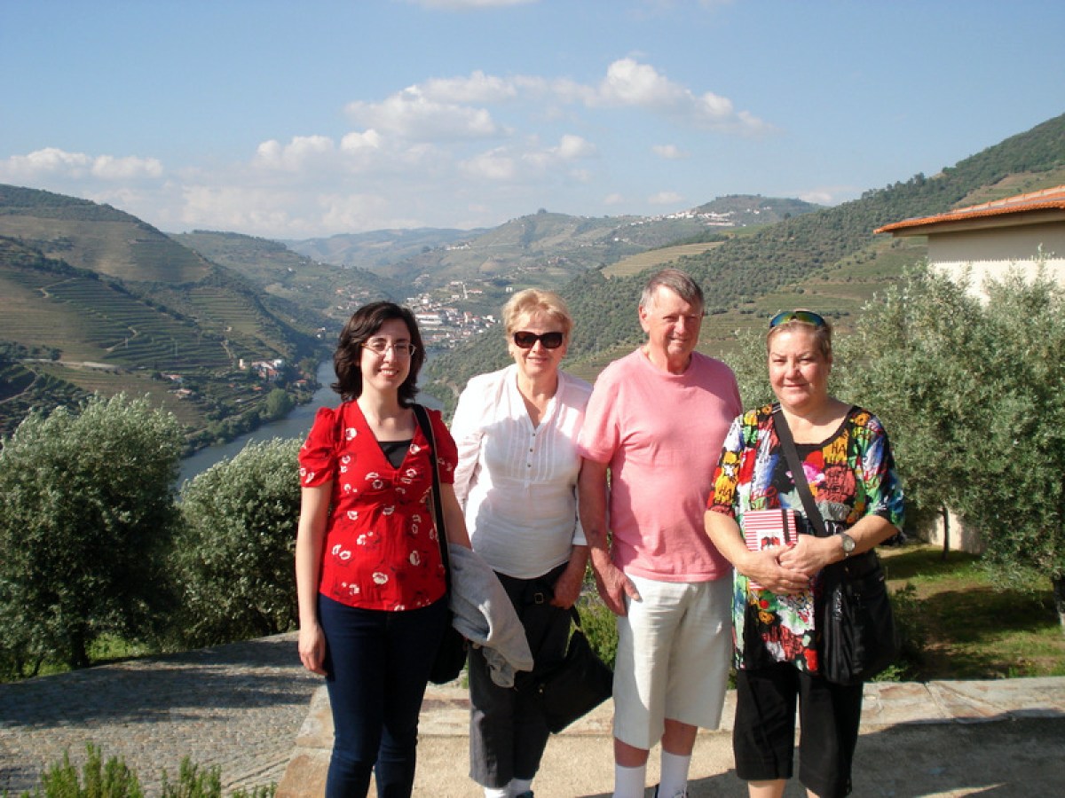 A small group of travelers enjoying a scenic stone path in the beautiful Douro Valley, surrounded by lush landscapes.