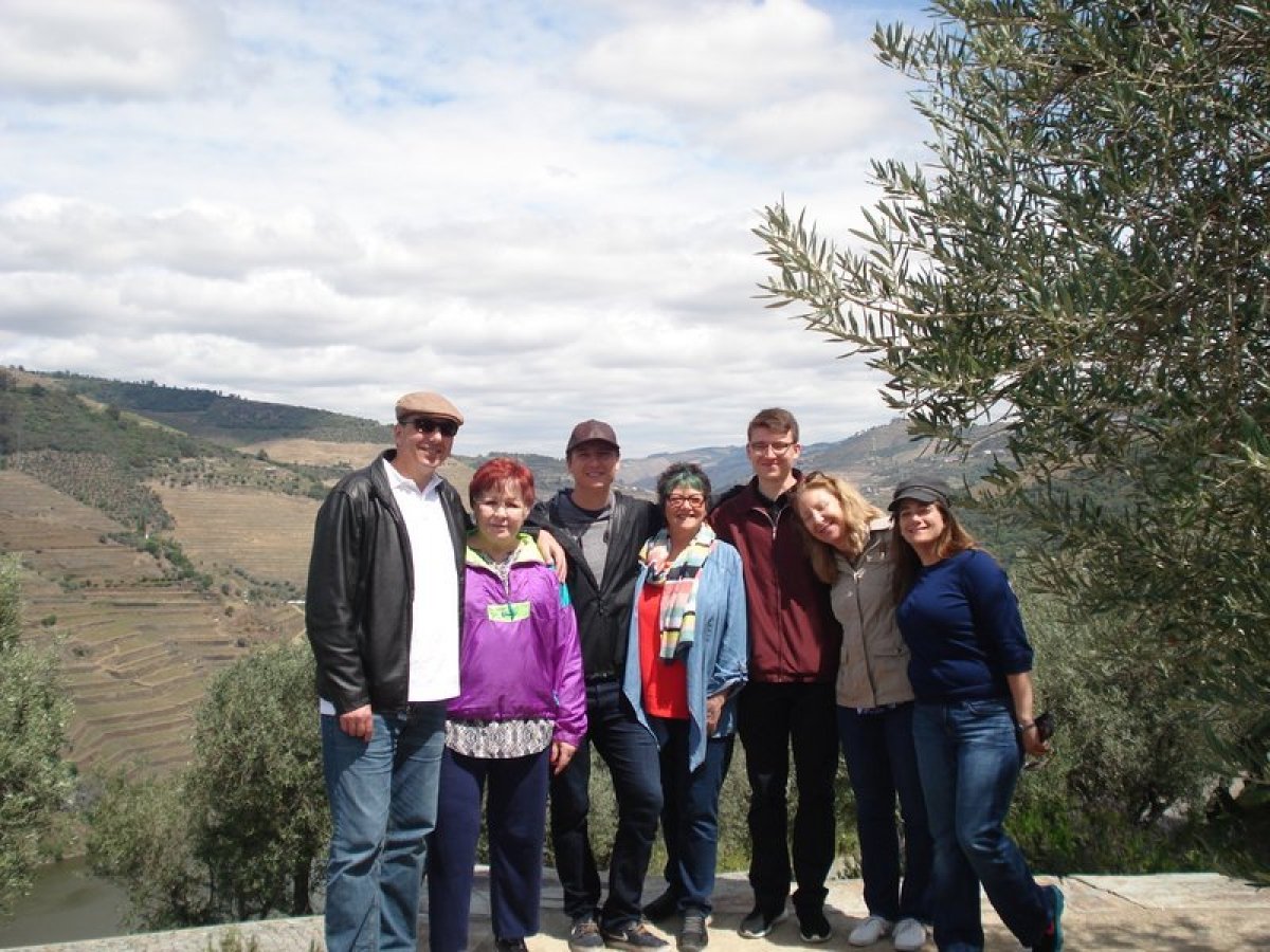 A joyful family group stands together, enjoying a scenic tour in the beautiful Douro Valley.