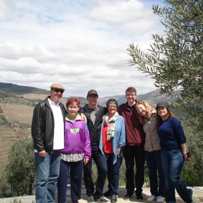A joyful family group stands together, enjoying a scenic tour in the beautiful Douro Valley.