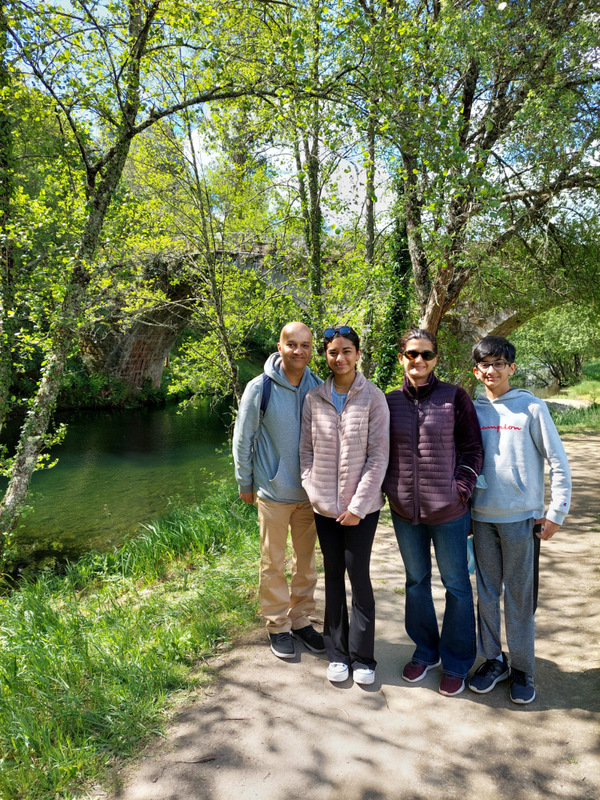 A family stands on a riverside path, enjoying the beautiful countryside of Portugal together.