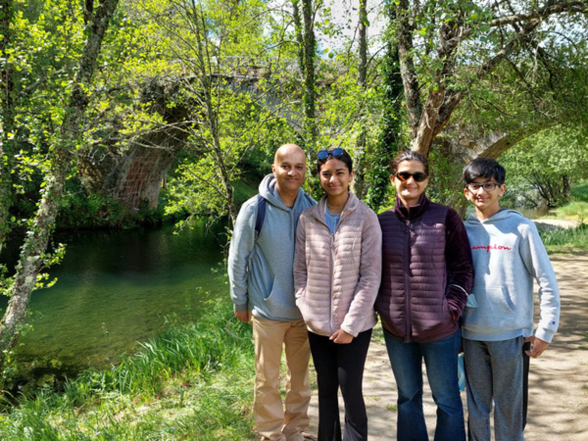 A family stands on a riverside path, enjoying the beautiful countryside of Portugal together.