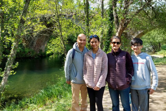 A family stands on a riverside path, enjoying the beautiful countryside of Portugal together.