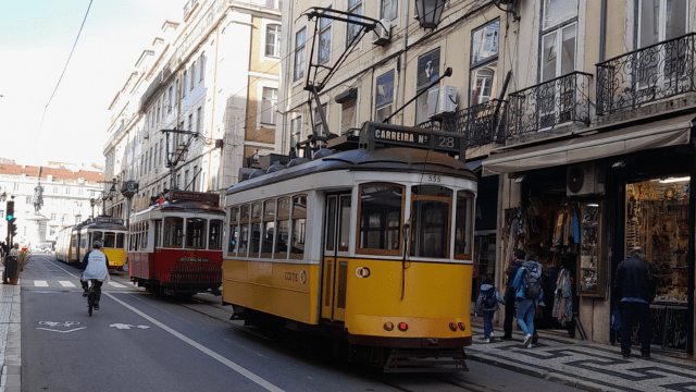 A vibrant Lisbon street scene featuring a colorful train, capturing the essence of a lively city tour.