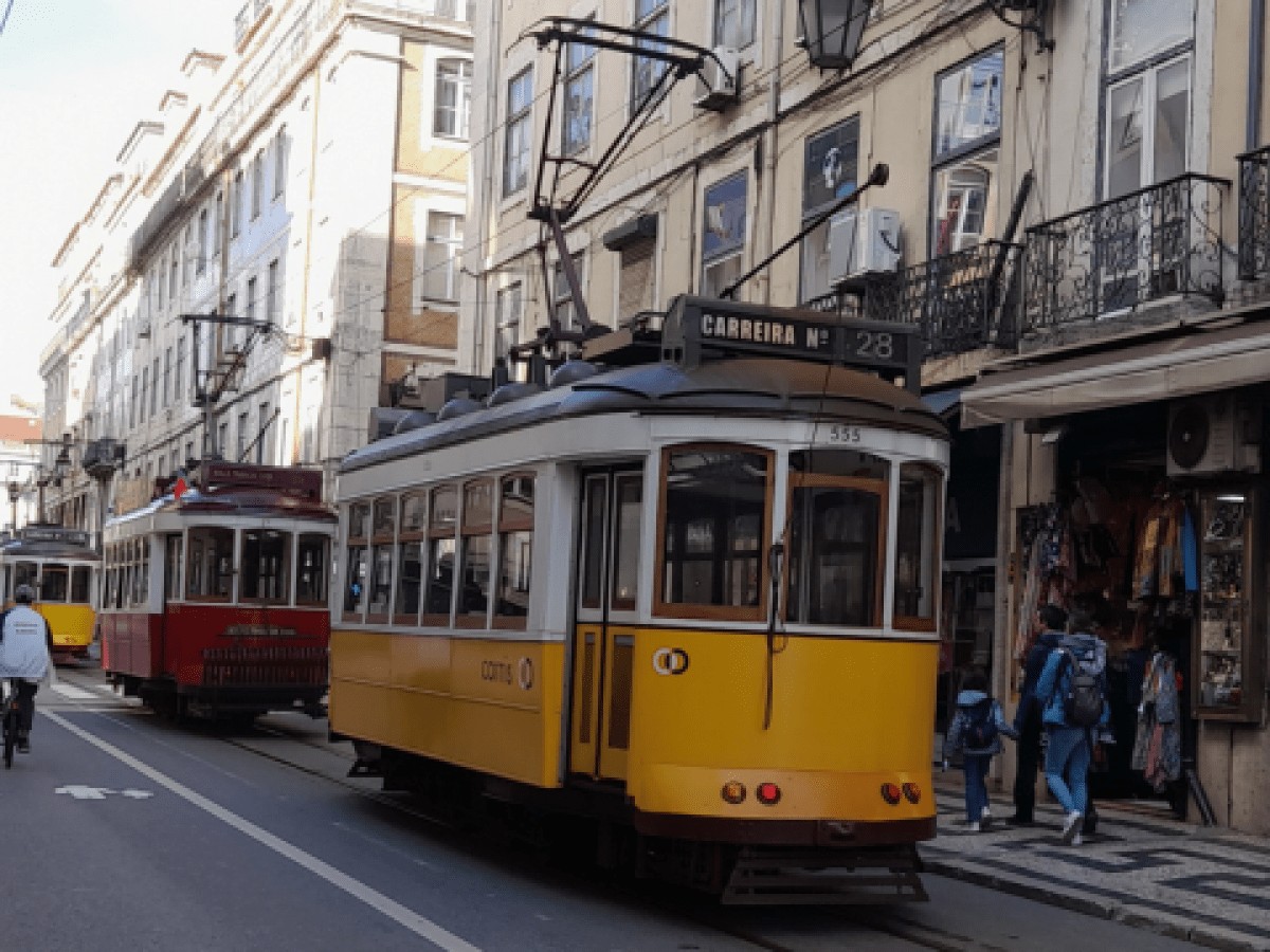 A vibrant Lisbon street scene featuring a colorful train, capturing the essence of a lively city tour.