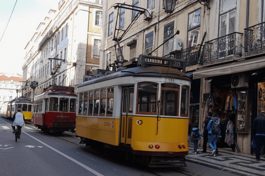 A vibrant Lisbon street scene featuring a colorful train, capturing the essence of a lively city tour.