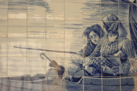 A vibrant blue and white tile mural shows two people in a boat, capturing the essence of Porto's scenic walking tours.