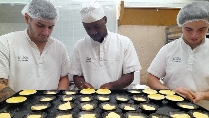 three men doing portuguese custard tarts lisbon