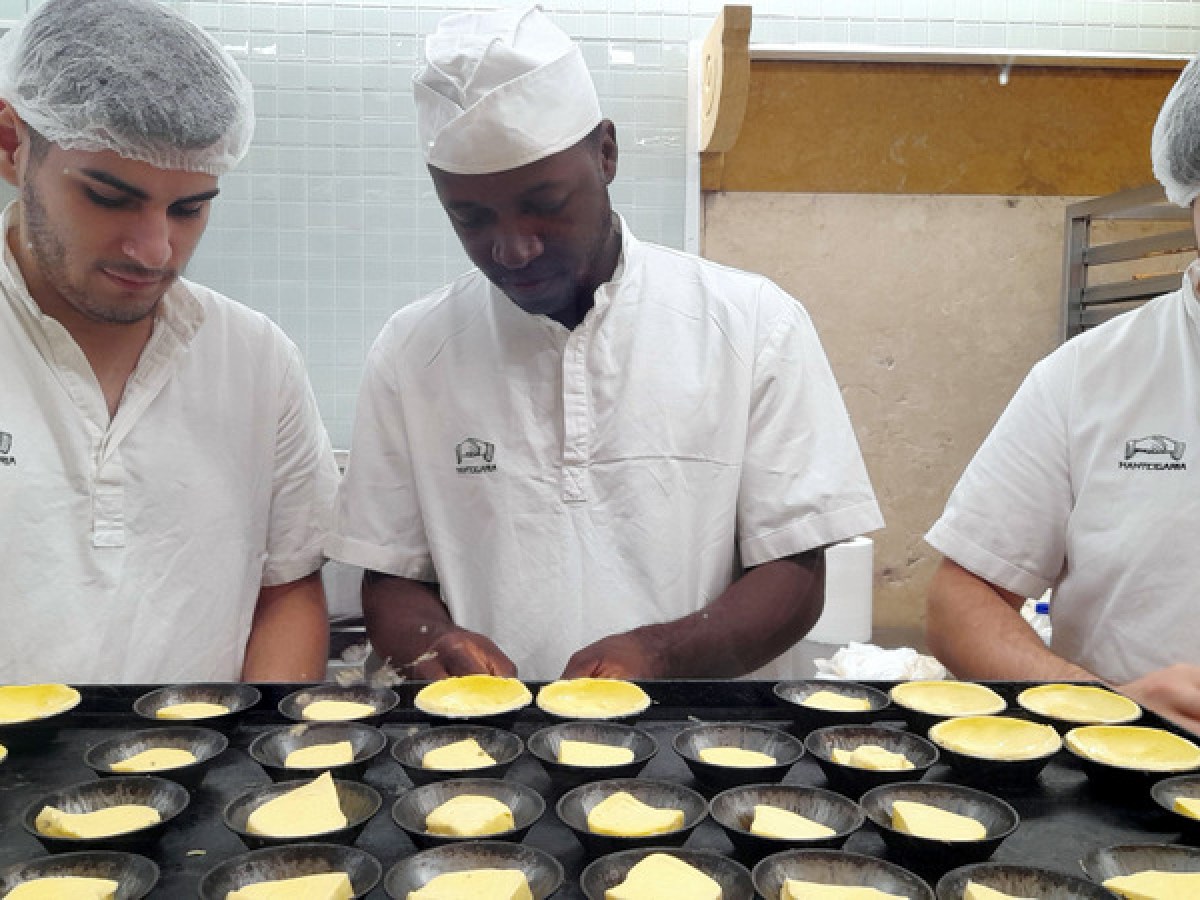 three men doing portuguese custard tarts lisbon