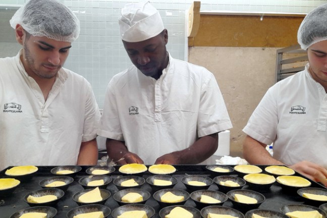three men doing portuguese custard tarts lisbon