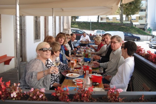 A lively group enjoying a meal together at a table during the Braga food tour, sharing laughter and delicious dishes.