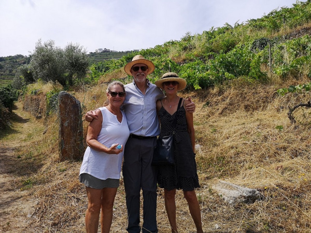 A man and two women stand on a dirt road, enjoying their Guided Walking Holidays in beautiful Portugal.