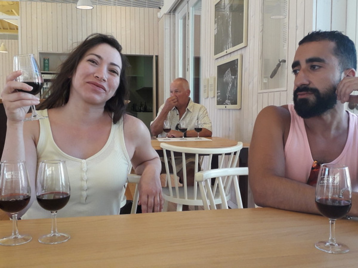 A man and woman enjoy a Douro wine tasting experience together at a cozy table, savoring fine wines and conversation.