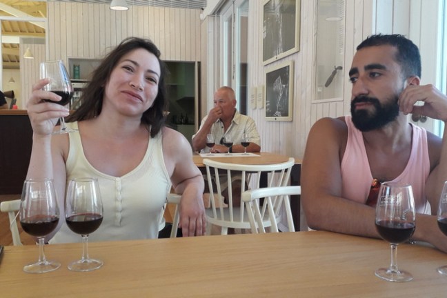 A man and woman enjoy a Douro wine tasting experience together at a cozy table, savoring fine wines and conversation.