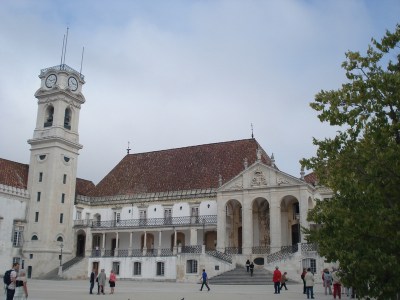 a group of people walking in front of University of Coimbra Portugal
