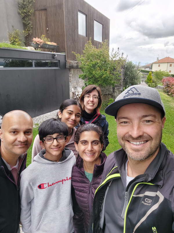 A cheerful group of tourists taking a selfie in front of a charming hotel during a Portugal wine and food tour.