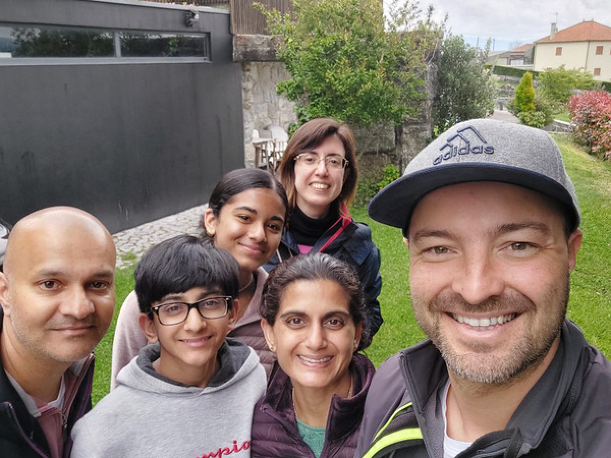 A cheerful group of tourists taking a selfie in front of a charming hotel during a Portugal wine and food tour.