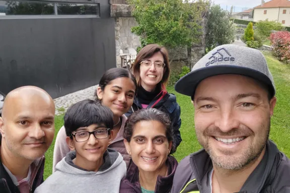 A cheerful group of tourists taking a selfie in front of a charming hotel during a Portugal wine and food tour.