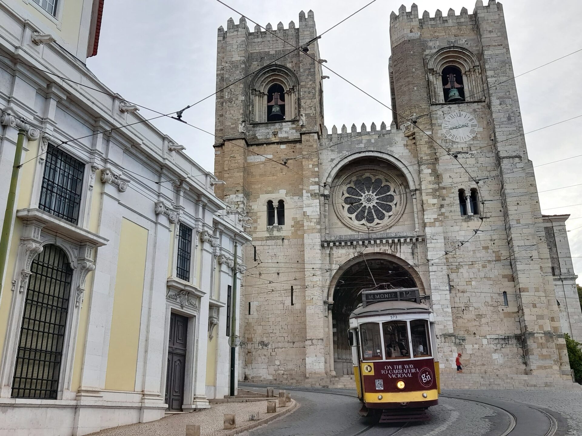 cathedral and yellow tram in lisbon