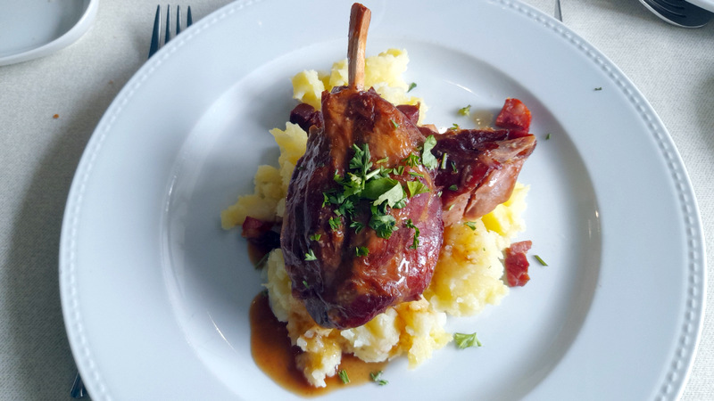a plate of pork with potatoes during portugal food tour