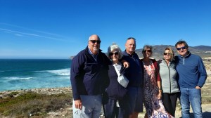 a group of people standing on a beach posing for the camera