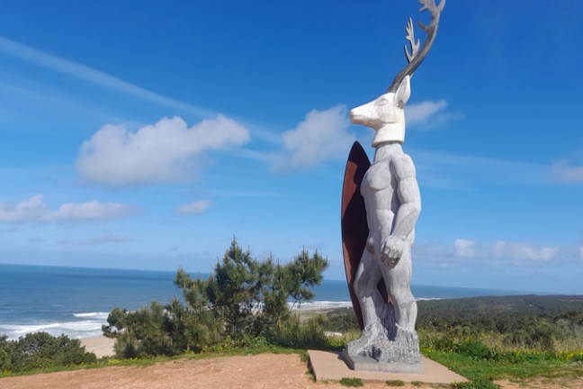 a statue in nazare beach praia norte big wave